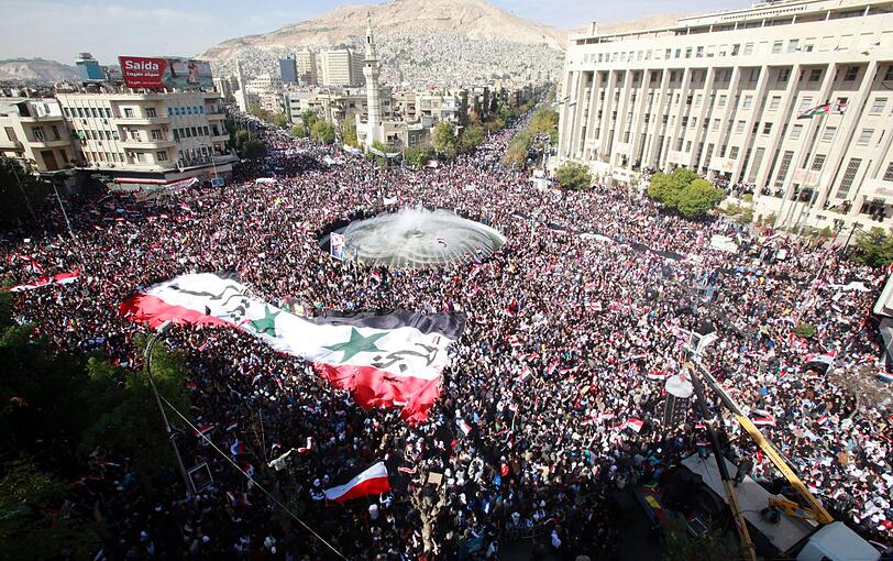 Das Epizentrum der Syrischen Proteste befindet sich in Damaskus. Bereits seit Frühling 2011 kommt es in Syrien im Rahmen des Arabischen Frühlings zu Demonstrationen, auf denen Demonstranten politische Freiheit und den Sturz der Regierung forderten. Die Regierung bekämpft die Proteste mit Gewalt.