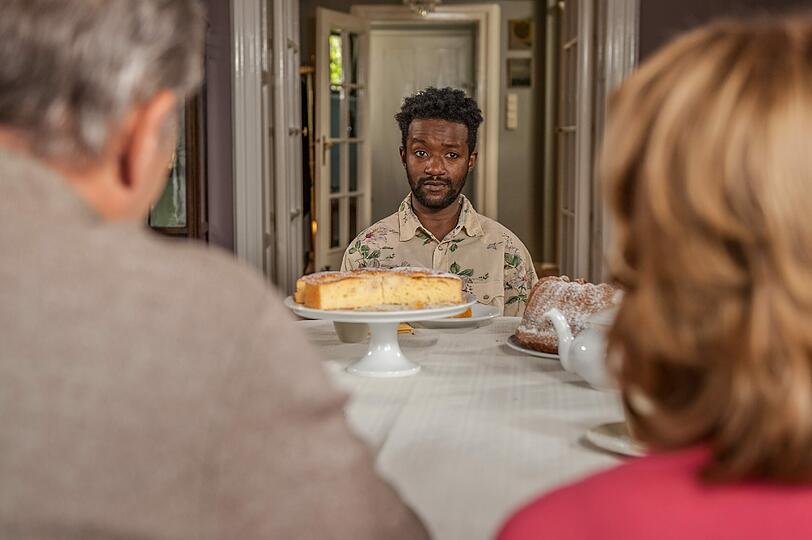Diallo (Eric Kabongo) durchschaut schnell, was bei den Hartmanns so alles schief läuft. Von hinten zu sehen: Senta Berger als Angelika und Heiner Lauterbach als Richard.