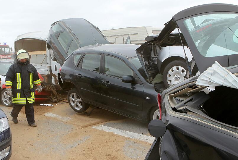 Feuerwehrleute sind am Freitag auf der Autobahn A19 bei Kavelstorf in der Nähe von Rostock bei einer Massenkarambolage im Einsatz. Bei einem Sandsturm fuhren in beiden Fahrtrichtungen Dutzende Fahrzeuge und LKW ineinander und brannten teilweise aus.