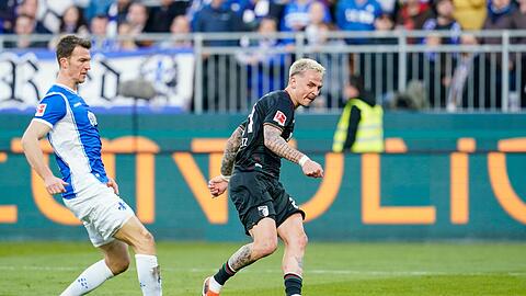 Augsburgs Phillip Tietz (r) schiesst das Tor zum 0:6. Darmstadts Christoph Zimmermann kommt zu spät.