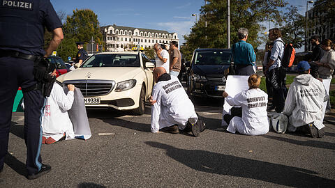 Blockade Scientists Rebellion in München Aktivist*innen in Kitteln bedruckt mit Scientist Rebellion. Am 28.Oktober 2022 blockierten Aktivist*innen, der Gruppen Scientists Rebellion, Extinction Rebellion und Letzte Generation, die Karlsstraße in München. Die Aktion soll auf die klimapoli
