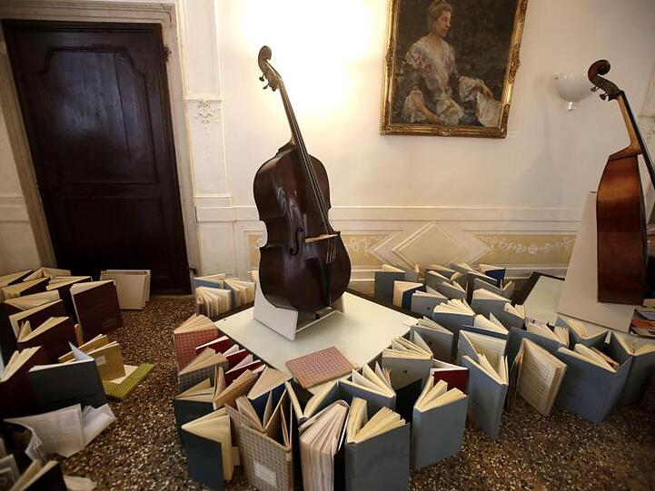 Musikinstrumente stehen im Konservatorium der Stadt Venedig auf einer aus Musikbüchern gebauten Empore, um vor Wasser geschützt zu werden.
