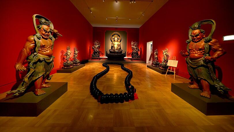 Im tiefroten Buddhasaal: In der Mitte liegt eine überdimensionale Gebetskette, die aus Bettelschalen der Bettelmönche gefertigt ist. Im tiefroten Buddhasaal: In der Mitte liegt eine überdimensionale Gebetskette, die aus Bettelschalen der Bettelmönche gefertigt ist.