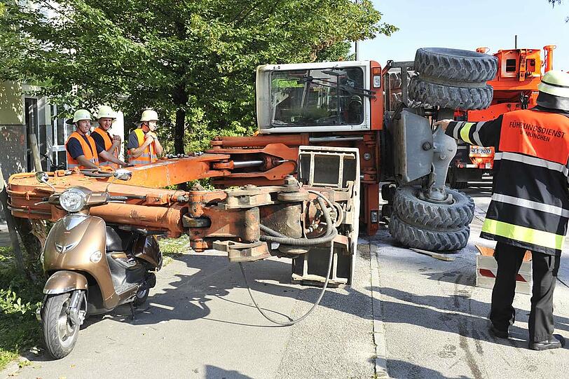 Tiefer gelegt: Ein Bagger ist umgekippt. Der Greifarm des Baugeräts landete direkt auf einem geparkten Motorroller.