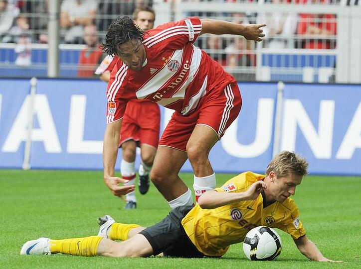 Jakub Blaszczykowski vom BVB (unten) kommt im Zweikampf mit Luca Toni zu Fall.