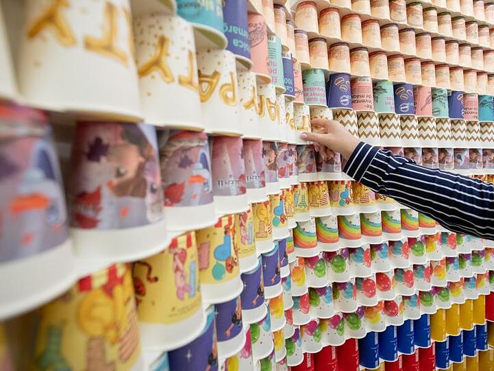 Zahlreiche Kaffebecher, bestehend aus 93 Prozent Papier, sind ausgestellt. Foto: Daniel Karmann