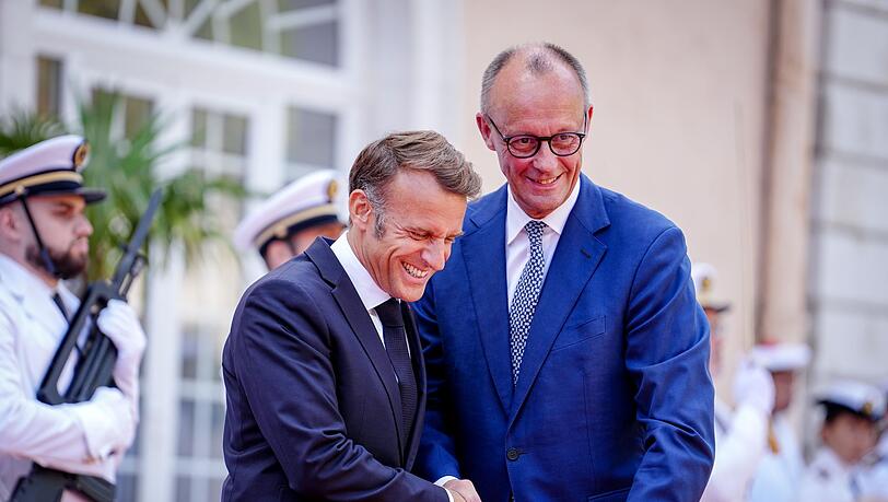 Wie zwei alte Freunde begrüßen sich Macron und Merz vor dem Fort du Cap Brun über der Cote d'Azur. Wie zwei alte Freunde begrüßen sich Macron und Merz vor dem Fort du Cap Brun über der Cote d'Azur.