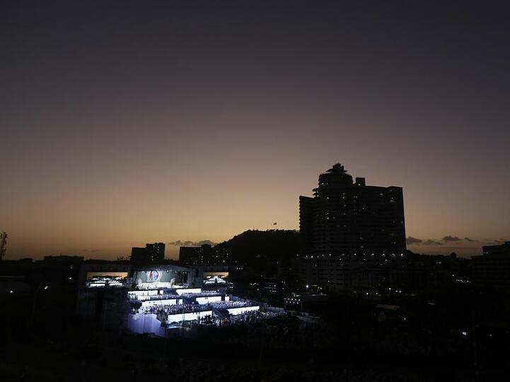 Pilger nehmen an der Eröffnungsfeier und Eröffnungsmesse in Panama-Stadt teil, während im Hintergrund die Sonne untergeht.