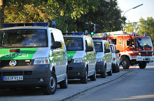 Einsatzfahrzeuge von Polizei und Feuerwehr stehen bereit.