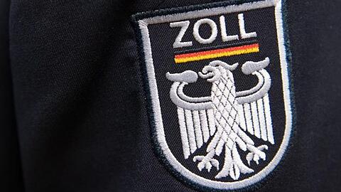 Das Wappen der Zollbehörde prangt auf einer Uniform. Foto: Ralf Hirschberger/dpa/Archivbild