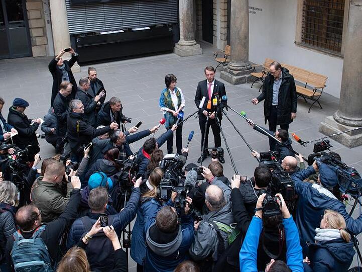 Umringt von Kameras und Mikrofonen: Eva-Maria Stange (SPD, l), Wissenschaftsministerin von Sachsen, und Roland Wöller (CDU, r), Innenminister von Sachsen, bei einer Pressekonferenz im Kleinen Schlosshof des Residenzschlosses in Dresden.