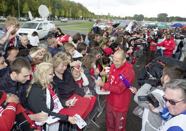 Arjen Robben schreibt Autogramme.
