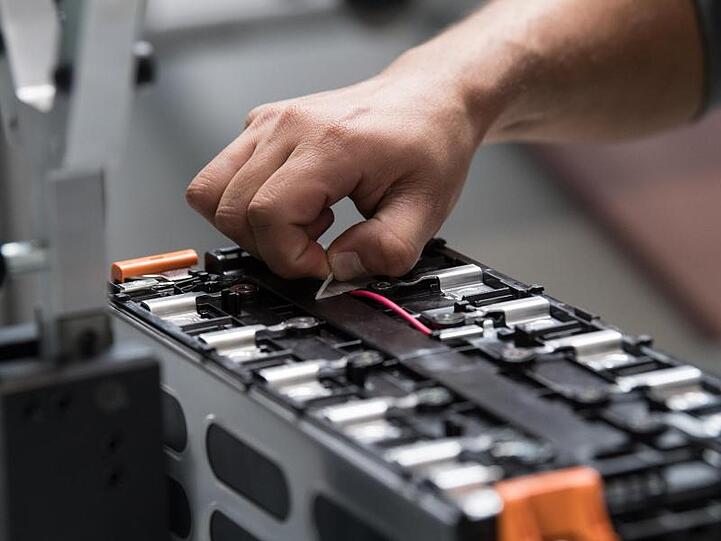 Ein Mitarbeiter arbeitet in der Batteriesystemfabrik von Akasol in Darmstadt an einer unfertigen Batterie.