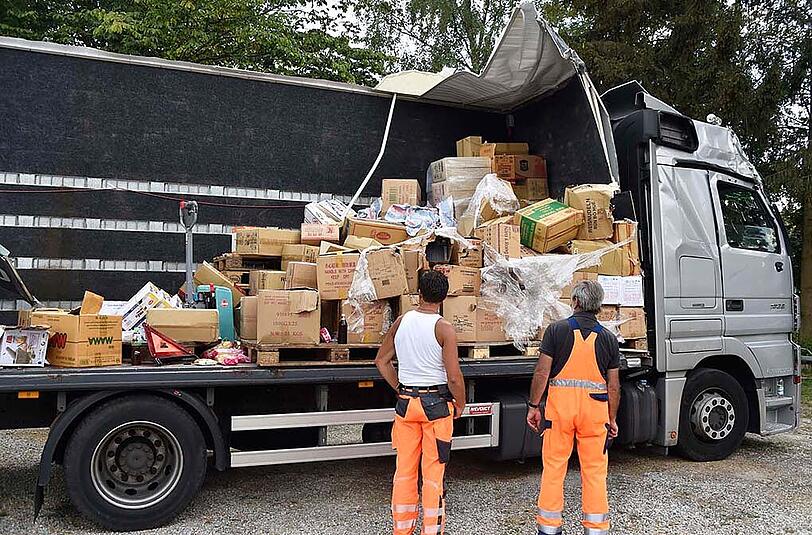 Der LKW ist vollkommen zerstört, Seitenwand und Dach des Aufbaus wurden von einem Baum an der Straße komplett abgerissen.