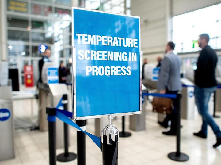 Sicherheitsmaßnahme auf der Reifenmesse in Hannover. Ein Schild weist am Eingang auf eine Einrichtung zur Messung der Körpertemperatur hin.