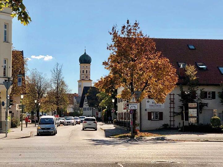 Blick in die Heiglhofstraße auf den alten Dorfkern von Hadern: Der Zwiebelturm der katholischen Barockkirche St. Peter und umgebende frühere Bauernhöfe. Mehr Münchner Dorfkerne hier zum Durchklicken.