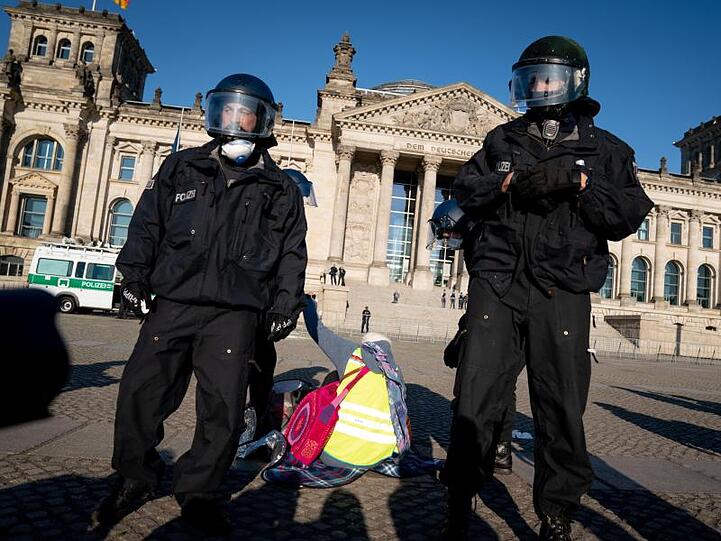 Polizeibeamte eine Demonstration vor dem Reichstagsgebäude in Berlin auf.