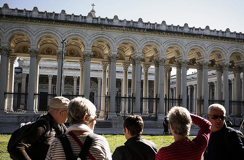 Touristen stehen vor geschlossenen Sehenswürdigkeiten - Risse zeigen sich überall.