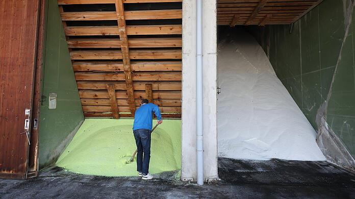 Ein Mitarbeiter schaufelt auf dem Betriebsgelände einer BayWa Filiale in einer Halle gelagertes Düngemittel der Sorte ALZON. Im Frühjahr decken sich landwirtschaftliche Betriebe mit Dünger ein, der für Wachstum und Erträge entscheidend ist, vor dem Hintergrund schwankender Gaspreise als zentralem Kostenfaktor. +++ dpa-Bildfunk +++ Ein Mitarbeiter schaufelt auf dem Betriebsgelände einer BayWa Filiale in einer Halle gelagertes Düngemittel der Sorte ALZON. Im Frühjahr decken sich landwirtschaftliche Betriebe mit Dünger ein, der für Wachstum und Erträge entscheidend ist, vor dem Hintergrund schwankender Gaspreise als zentralem Kostenfaktor. +++ dpa-Bildfunk +++