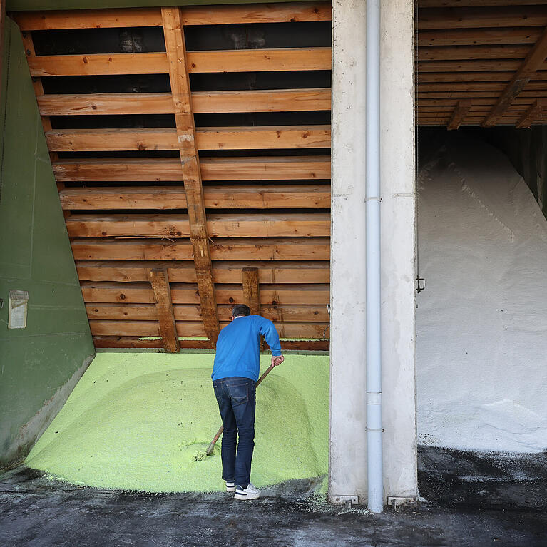 Ein Mitarbeiter schaufelt auf dem Betriebsgel&auml;nde einer BayWa Filiale in einer Halle gelagertes D&uuml;ngemittel der Sorte ALZON. Im Fr&uuml;hjahr decken sich landwirtschaftliche Betriebe mit D&uuml;nger ein, der f&uuml;r Wachstum und Ertr&auml;ge entscheidend ist, vor dem Hintergrund schwankender Gaspreise als zentralem Kostenfaktor. +++ dpa-Bildfunk +++
