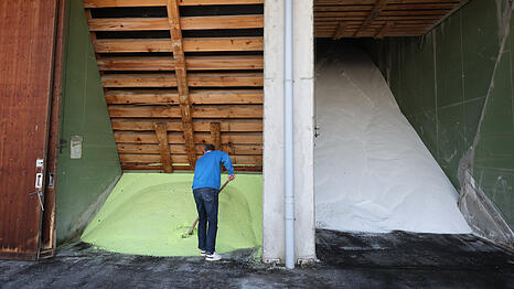 Ein Mitarbeiter schaufelt auf dem Betriebsgel&auml;nde einer BayWa Filiale in einer Halle gelagertes D&uuml;ngemittel der Sorte ALZON. Im Fr&uuml;hjahr decken sich landwirtschaftliche Betriebe mit D&uuml;nger ein, der f&uuml;r Wachstum und Ertr&auml;ge entscheidend ist, vor dem Hintergrund schwankender Gaspreise als zentralem Kostenfaktor. +++ dpa-Bildfunk +++