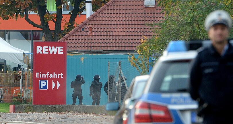 Mit erhobenen Händen kommt ein Mann auf die SEK-Beamten zu, im Hintergrund lauern Heckenschützen der Polizei. Die Beamten nehmen den Mann fest, es ist aber nicht der Täter, der sich in einem Imbiss in Freiburg veschanzt hat.