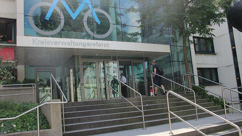 Leute warten vor dem KVR Gebäude.