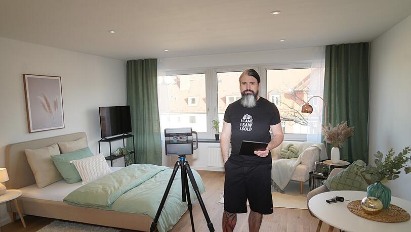 Michael Perkmann in einem Neuhauser Einzimmer-Apartment, das er bald vermietet. Links von ihm: eine Hightech-360-Grad-Kamera für 4.500 Euro. Sie ermöglicht Miet- oder Kaufinteressenten einen digitalen, dreidimensionalen Rundgang.