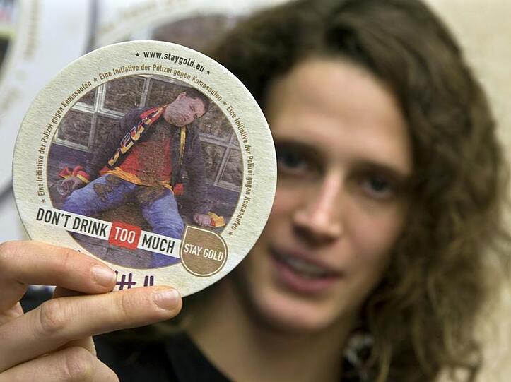 Olympiasiegerin Lena Schöneborn zeigt einen der Kampagnen-Bierdeckel.