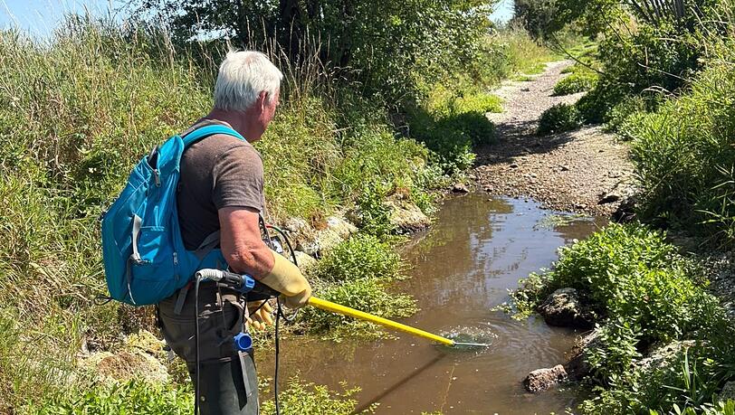 Ein Isarfischer fischt Fische aus dem Hüllgraben, sie werden umgesetzt. Ein Isarfischer fischt Fische aus dem Hüllgraben, sie werden umgesetzt.