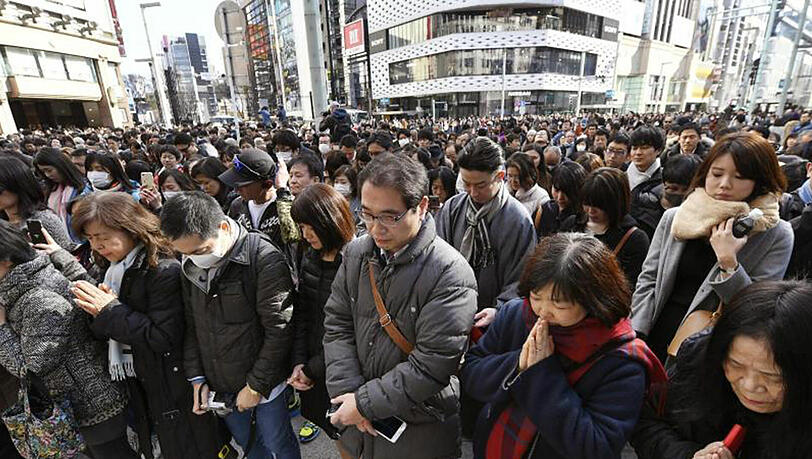 Menschen gedenken im Ginza-Einkaufsviertel in Tokio der Opfer, die 2011 bei der Natur- und Atomkatastrophe von Fukushima getötet wurden. Menschen gedenken im Ginza-Einkaufsviertel in Tokio der Opfer, die 2011 bei der Natur- und Atomkatastrophe von Fukushima getötet wurden.
