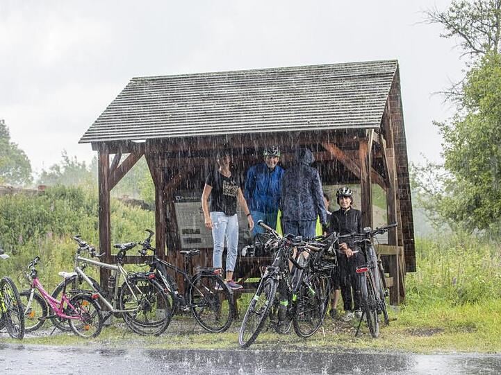 Ausflügler haben sich bei starkem Regen im Erzgebirge untergestellt.