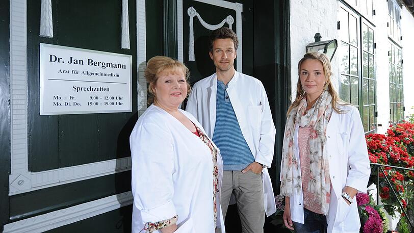 Franziska Troeger als Gertrud Hinnerksen (v.l.), Wayne Carpendale als Doktor Jan Bergmann und Lea Faßbender als Anja Steinwehr posieren am Set der Fernsehserie "Der Landarzt". 2013 ist die letzte Folge ausgestrahlt worden. Auch in der Realität stirbt der Mediziner auf dem Land aus.