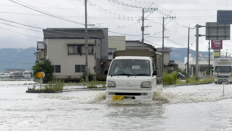 Eine Straße in Tachiarai in der Präfektur Fukuoka im Südwesten Japans steht nach starken Regenfälle unter Wasser. Eine Straße in Tachiarai in der Präfektur Fukuoka im Südwesten Japans steht nach starken Regenfälle unter Wasser.
