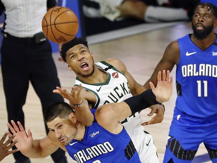 Nikola Vucevic (vorn) von Orlando Magic bremst Giannis Antetokounmpo (M) von den Milwaukee Bucks.