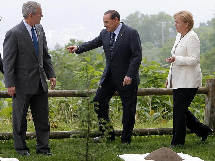 Gemeinsam pflanzen Bundeskanzlerin Angela Merkel (r), US-Präsident George W. Bush und der italienische Regierungschef Silvio Berlusconi (M) einen jungen Baum.