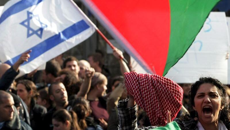 Die Fahne Israels und die Farben der Palästinenser bei einer Demonstration in Jerusalem. Die Fahne Israels und die Farben der Palästinenser bei einer Demonstration in Jerusalem.