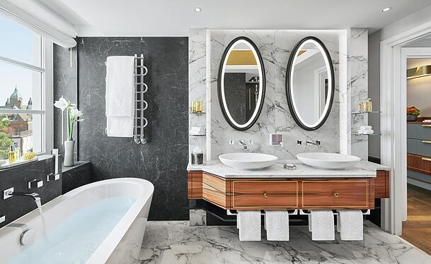 Das Bad der Turm-Suite mit Badewanne, einer begehbaren Dusche und zwei Waschtischen.