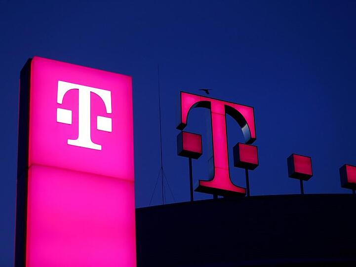 Das Logo der Deutschen Telekom leuchtet auf dem Dach der Unternehmenszentrale in BOnn.