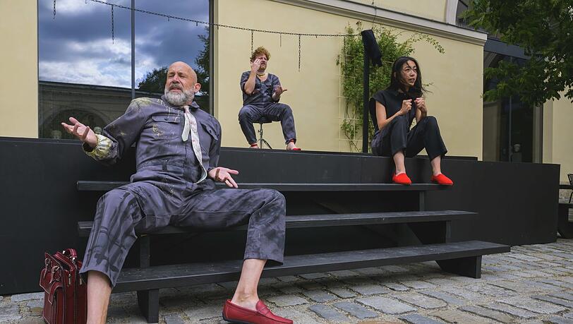 Im klassizistischen Innenhof am Königsplatz: Sven Schöcker als Admetos, dessen Frau Alkestis (Roland Schreglmann, Mitte) sich für ihn opfert und Thin Le Thanh Ho als kommentierende Dienerin, die auch Chorpassagen übernimmt.
