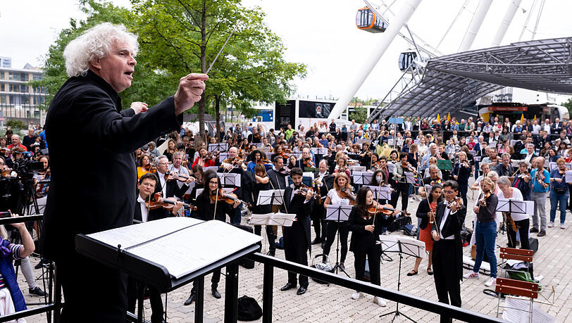 Simon Rattle 2022 bei einem symphonischen Flashmob vor dem Bauplatz.