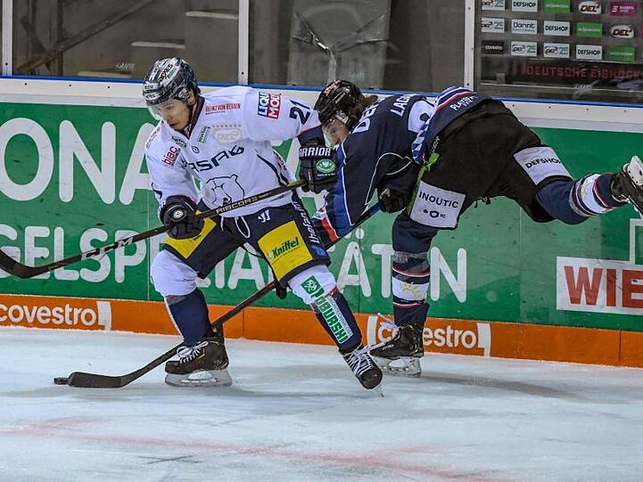 Antoine Laganiere von den Straubing Tigers (r) und Austin Ortega von den Eisbären Berlin kämpfen um den Puck. Foto: Armin Weigel