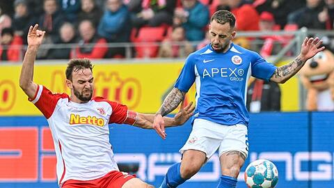 Benedikt Gimber von Regensburg (l) und Calogero Rizzuto von Rostock kämpfen um den Ball.