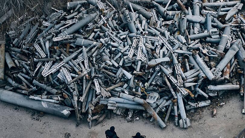 Polizeibeamte betrachten die eingesammelten Fragmente von Raketen, die in Charkiw eingeschlagen sind.