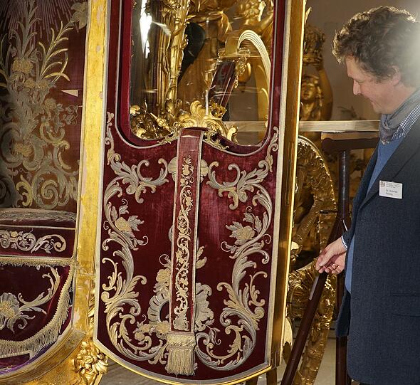 Chef-Restaurateur Heinrich Piening zeigt den Seidensamt, mit dem die ganze Kabine des Königs ausgekleidet ist.
