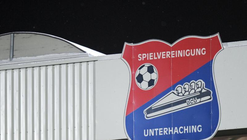 Ein Schild mit der Aufschrift "Spielvereinigung Unterhaching" ist an der Tribüne befestigt. Foto: picture alliance / dpa / Archivbild Ein Schild mit der Aufschrift "Spielvereinigung Unterhaching" ist an der Tribüne befestigt. Foto: picture alliance / dpa / Archivbild