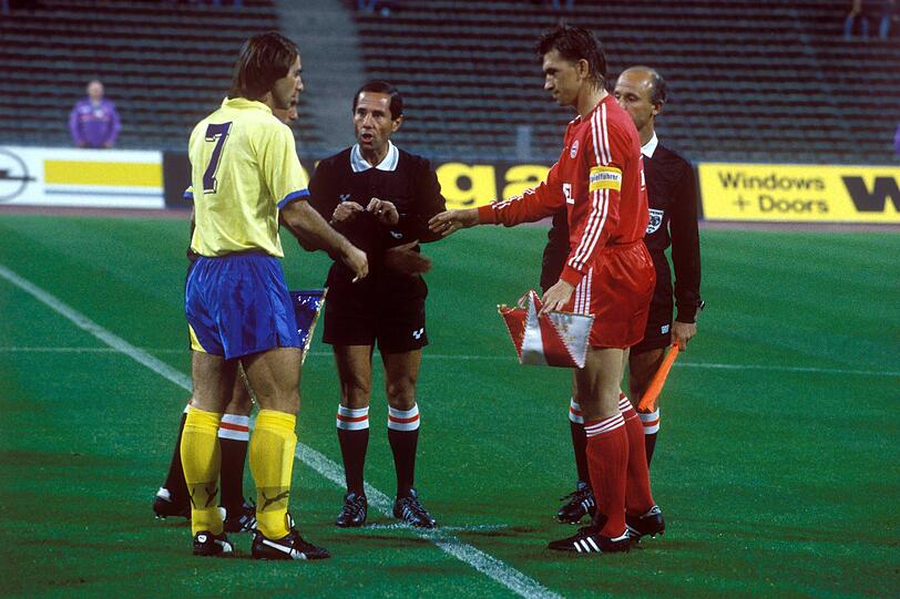 APOEL-Kapitän Pantzaras (Nikosia, li.) und Klaus Augenthaler (Bayern, re.) bei der Begrüßung, dahinter das Schiedsrichtergespann.