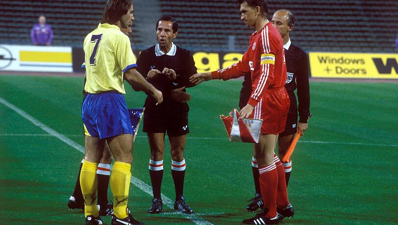 APOEL-Kapitän Pantzaras (Nikosia, li.) und Klaus Augenthaler (Bayern, re.) bei der Begrüßung, dahinter das Schiedsrichtergespann. APOEL-Kapitän Pantzaras (Nikosia, li.) und Klaus Augenthaler (Bayern, re.) bei der Begrüßung, dahinter das Schiedsrichtergespann.