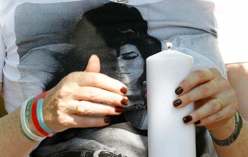 Ein weiblicher Fan zündet eine Kerze für Amy Winehouse an. Die Britin war vergangenes Jahr im Alter von nur 27 Jahren in London an einer Alkoholvergiftung gestorben. In ihrem Blut wurde ein Alkoholgehalt von 4,16 Promille festgestellt worden, wodurch wahrscheinlich ihre Atmung aussetzte.