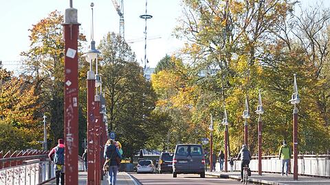 Fußgänger, Autos und Radler: Wo wer auf der Thalkirchner Brücke fahren oder gehen soll, ist nicht immer klar. Nun will die CSU die Brücke breiter machen.